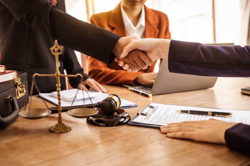 Shaking hands, lawyers provide legal guidance, represent clients in court, and assist with legal documentation. They analyze laws to protect their clients' rights and interests, ensuring fair representation and the pursuit of justice.