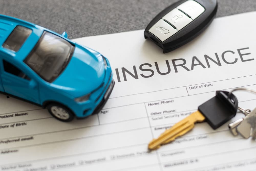 Toy car placed on top of a car insurance claim form.