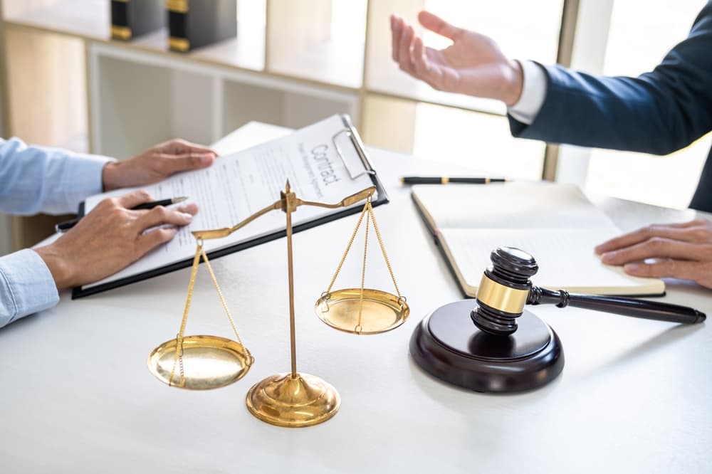 Male lawyer and a professional businesswoman discuss legal matters during a consultation at a law firm. Client seeks advice during a free consultation.