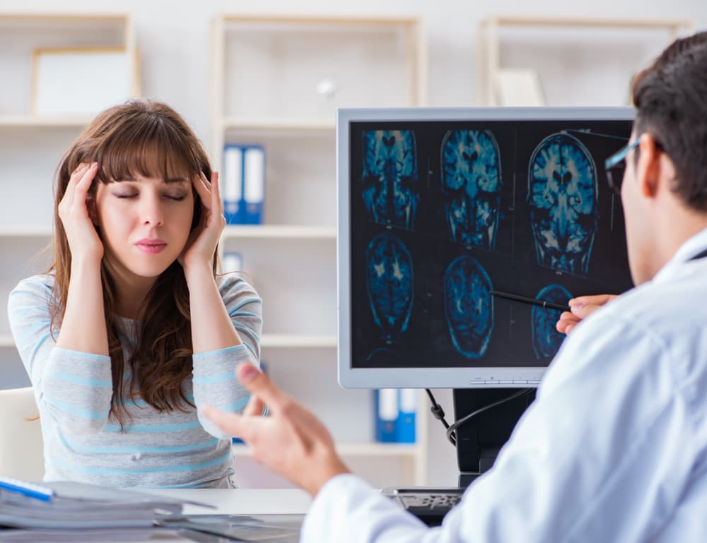 Young female patient undergoing an X-ray examination with a radiologist for medical diagnostics.