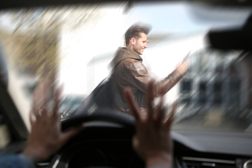 A young man engrossed in his phone, oblivious to his surroundings, crosses the street and becomes involved in an accident.