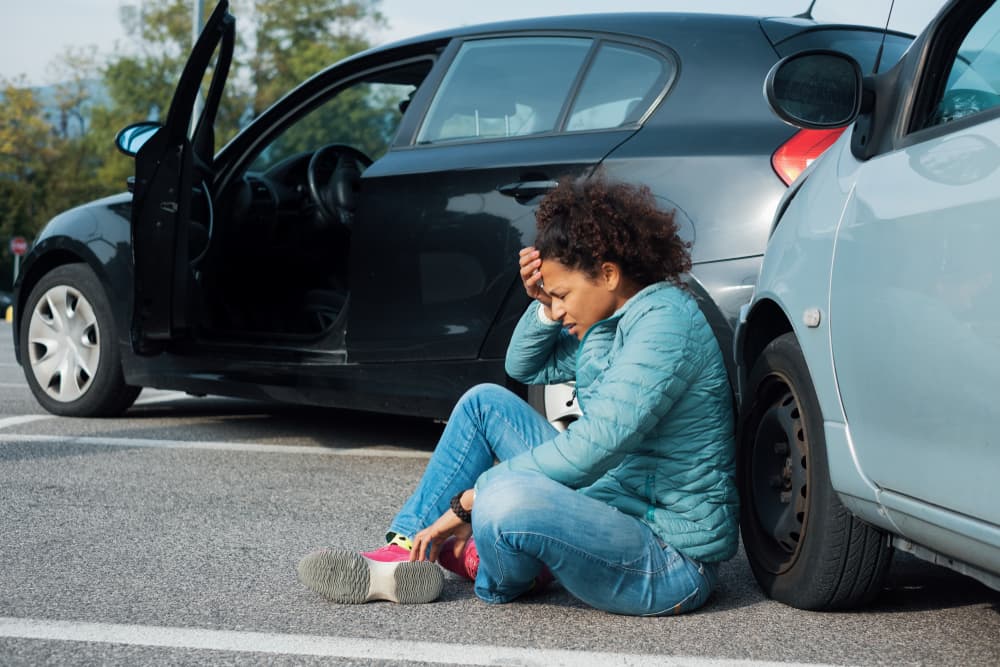 A victim in pain awaiting first aid after a rear-end collision, highlighting the urgency and aftermath of the accident.