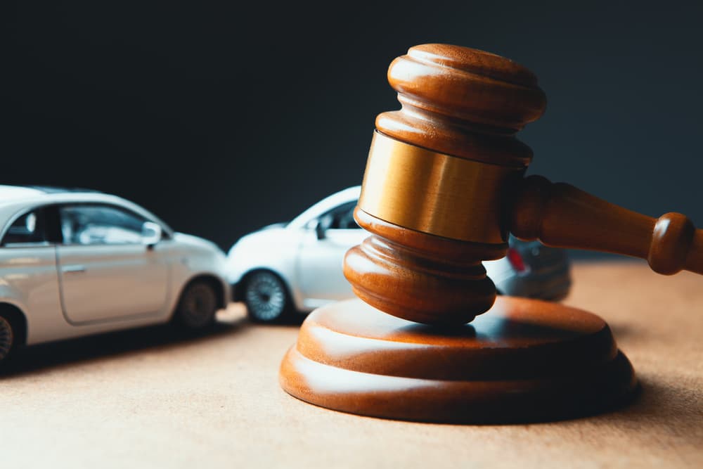 Car model next to gavel symbolizing accident lawsuit, insurance claim, or court case.