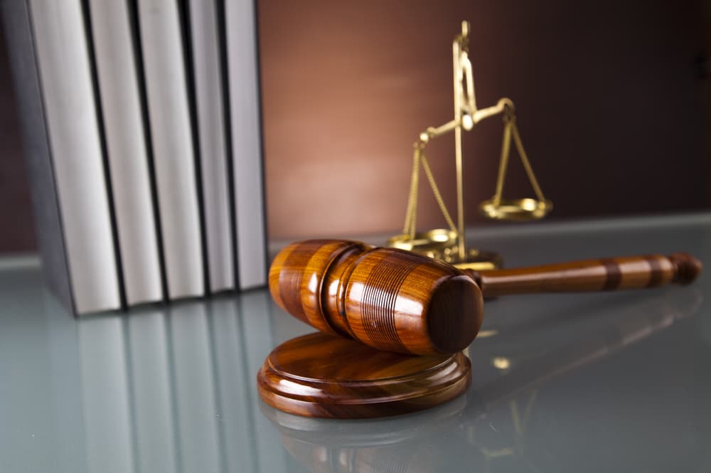 Scales of justice, wooden gavel, and legal books symbolizing law, fairness, and the judicial system.