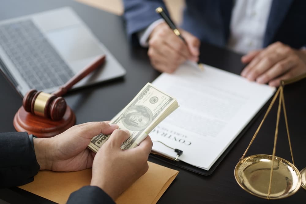 Close-up of a young lawyer signing a contract after finalizing an agreement with a client.