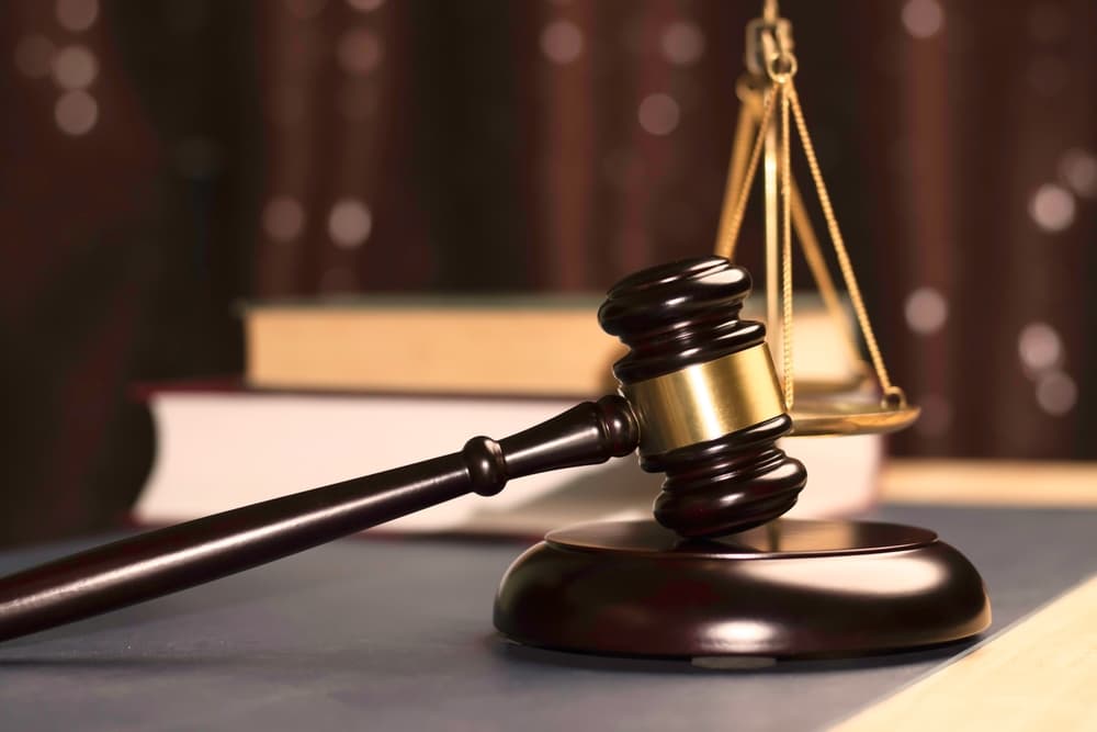 A lawyer’s hand with a judge’s gavel symbolizes justice, legal expertise, and digital-era representation—ideal for hiring legal advisors, consultants, or handling lawsuits and investigations.